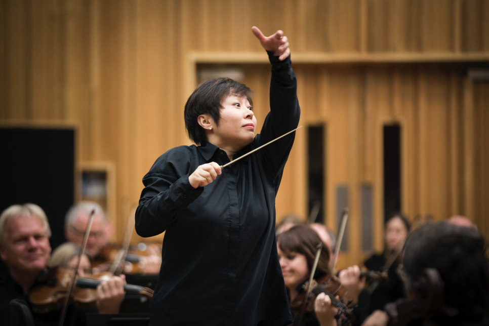 Closeup of the conductor Xian Zhang and BBC NOW orchestra