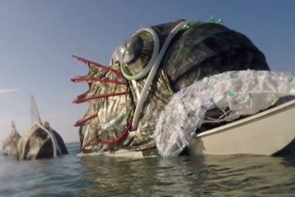 Large fish sculpture in the sea made out of rubbish 