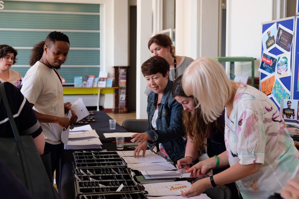 Administrators giving out name badges at a makeshift welcome desk