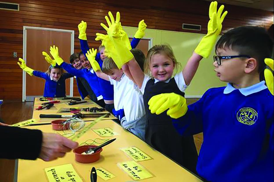 Children wearing yellow rubber gloves undertake art work