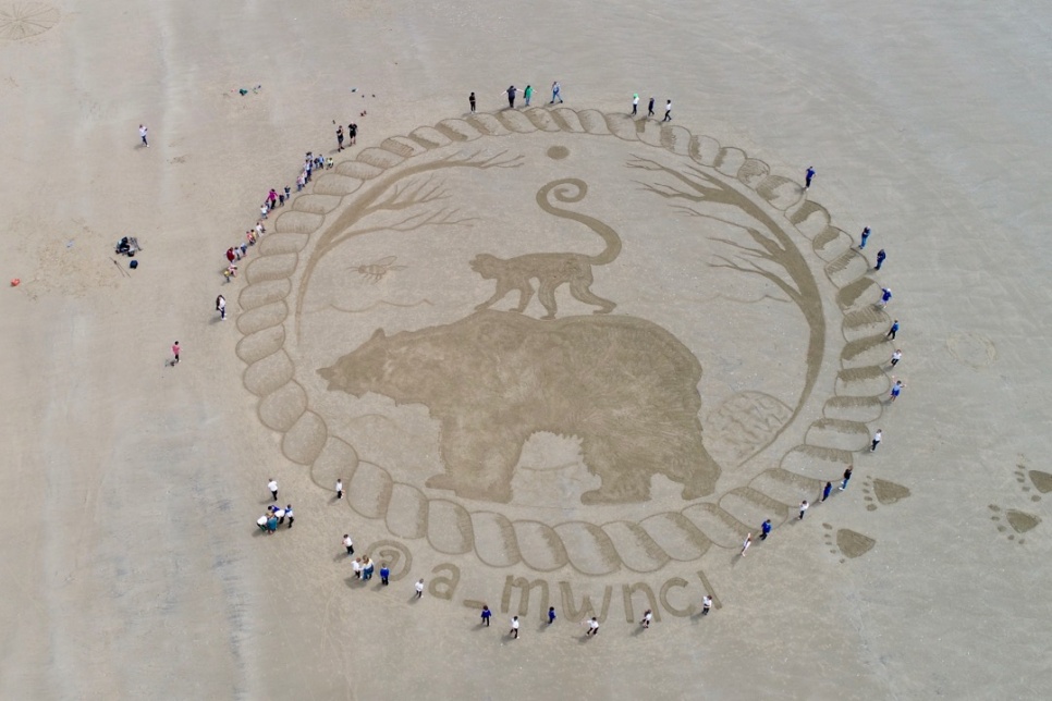 Sand art showing a bear and monkey on Cefn Sidan beach