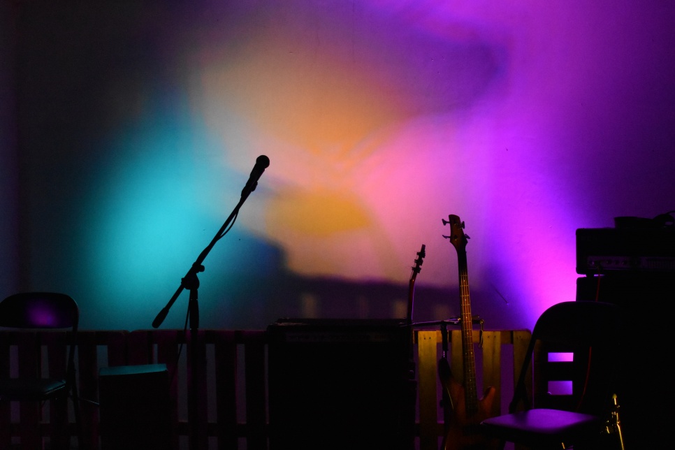 Multicoloured stage lights with silhouettes of microphone & instruments