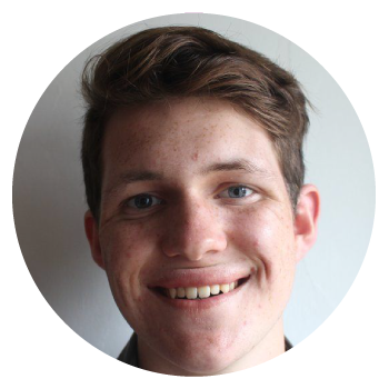 Hedydd Ioan smiling in a close up photograph in front of a white wall.