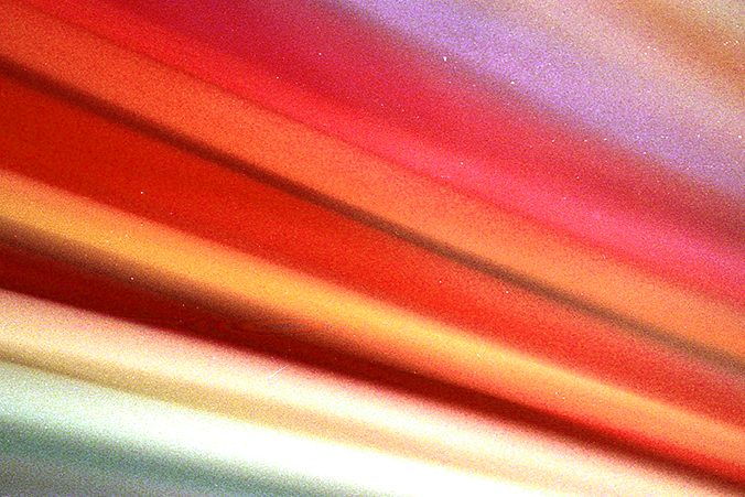 Abstract image with beams of light in shades of red and orange sweeping across the image