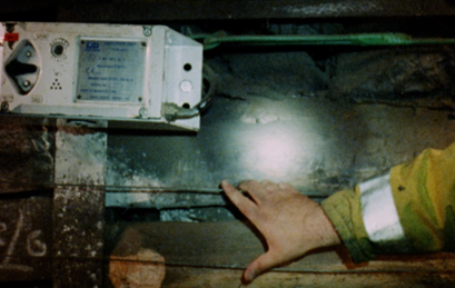 an image from the Signals exhibition with a hand reaching for mechnical equipment