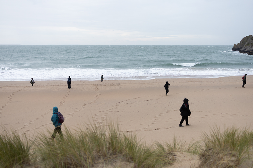 figures walking on a beach