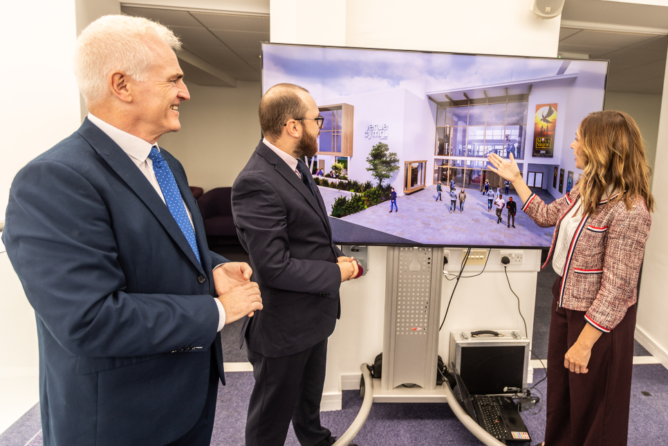 Three people looking at a set of visualisations and floor plans.