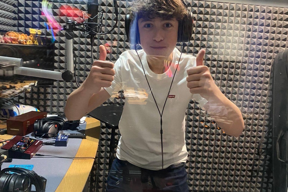 Photograph of a person in a recording studio / Ffotograff o berson mewn stiwdio recordio