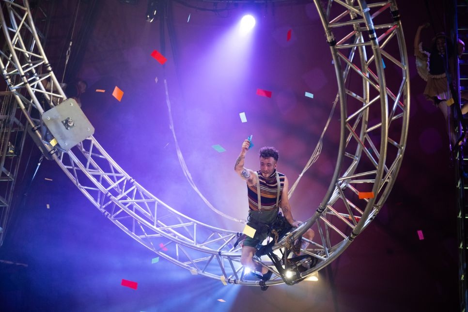 person sitting on a large metal wheel