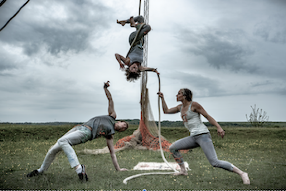 three circus artists in an open field