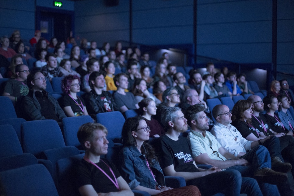 People sitting down in a cinema / Pobl yn eistedd i lawr mewn sinema